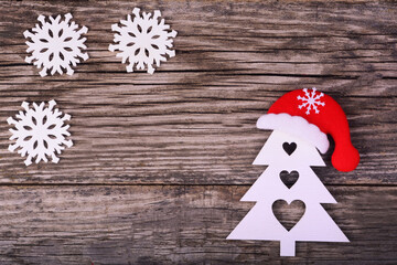 Wooden Christmas tree and snowflakes on a wooden background. Greeting card or holiday invitation.