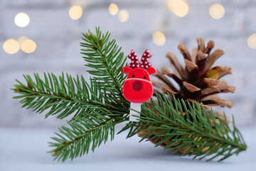 Christmas composition with fir branches decorated with the symbol of 2021 bull cow and red gift box on gray background with lights bokeh