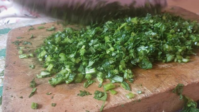 close up view of a women cutting persil in a traditional way
