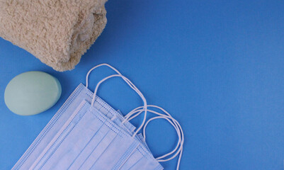 Protective mask, soap and towel on a blue background