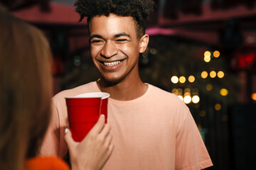 Group of happy young friends celebrating in the nightclub, dancing, drinking
