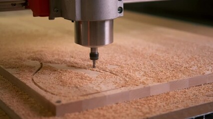 CNC drill drills a wooden cutting Board. Shavings fly in different directions
