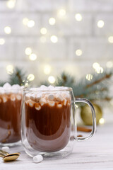 Glass cup of brown cocoa with marshmeloy on the buckground of gold bokeh, New Year hot drink