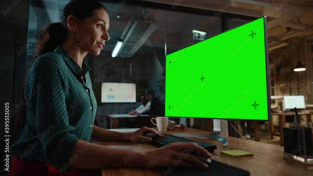 Aufkleber Middle Aged Multiethnic Specialist Working on Desktop Computer with Green Screen Mock Up Display in Busy Creative Office. Beautiful Diverse Female Manager in Green Polka Dot Blouse.