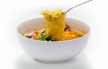 Tom Yum Kung is favorite taste of Thai cuisine with yellow noodle and vegetable ingredient in the white bowl. 