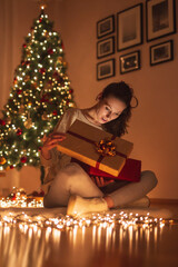 Obraz na płótnie Canvas Woman opening presents for Christmas Eve