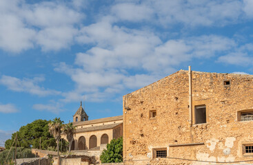 Church in the Majorcan town of Campos next to a rustic stone building