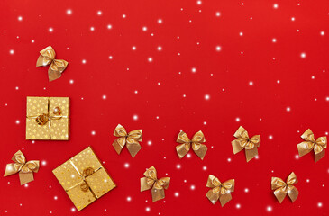 New Year's composition of gold gift boxes and Christmas decorations, imitation of snow on a red background. Flat lay, top view.