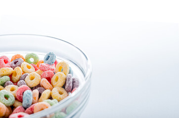 Colored fruit grain loops in a bowl.on a blue background