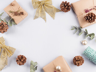 Christmas festive frame with wrapped zero waste presents, bows, pine cones on gray background.