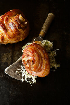Grilled pork knuckles with sauerkraut on a meat cleaver