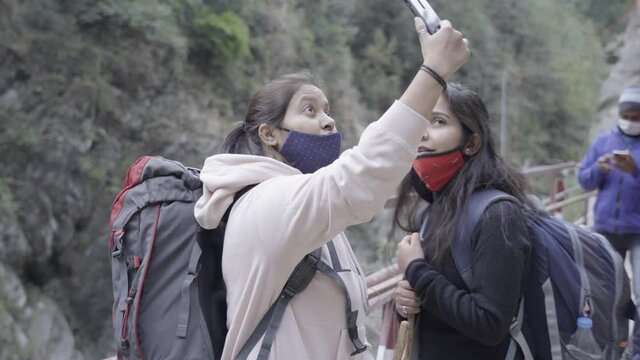Girls clicking pictures while trekking Kedarnath Temple trek. High quality 4k footage