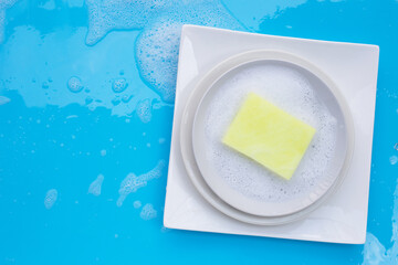 Washing dishes concept on wet blue background. Top view