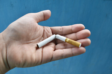 Quit smoking concept with hand holding broken cigarette