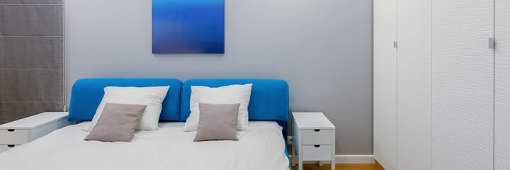 Modern bedroom in white and blue, panorama