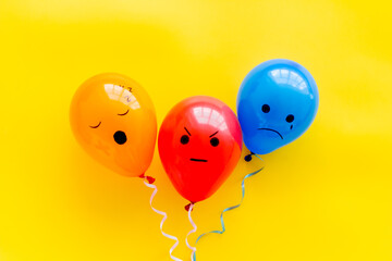 Negative emotions painted on ballon. Angry sad mood background. Top view
