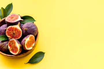 Fresh ripe figs in a bowl with leaves. Mediterranean fruit background