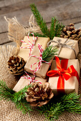 Christmas gift boxes in ecofriendly craft paper. Gifts in a wooden box on a wooden table. Eco-friendly gift packaging	