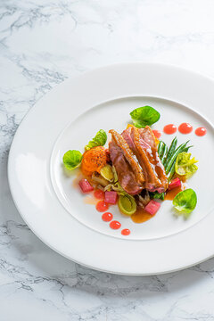 duck breast with beans, ginger carrot puree, leeks, rhubarb gel and rhubarb compot, brussel sprouts leaves.