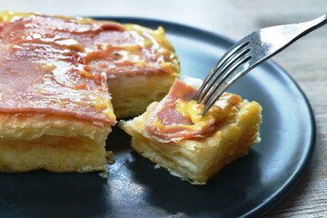 grilled toast topping ham pork and cheese stabbing by fork on plate