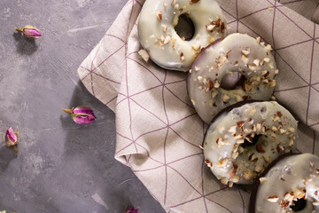 delicious fresh homemade donuts from the oven on a dark table with flowers and cocoa