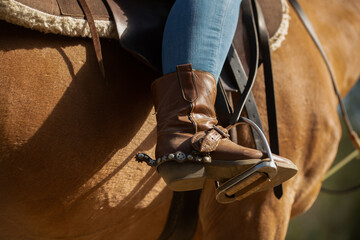 Cowboy boot in stirrup. Horseback riding. Wild West. Horse.
