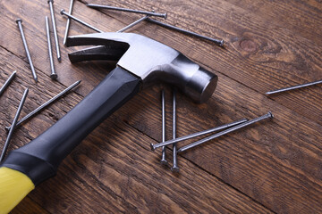 Hammer iron and nails on wooden background