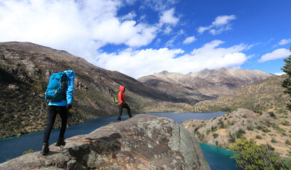 Fototapeta premium Two women backpackers hiking in beautiful winter mountains