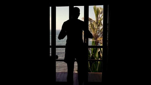 Man opening door and walking out on terrace with beautiful sea view, 240fps 
