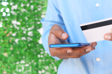 Man hand holding credit card and using smart phone shopping online 