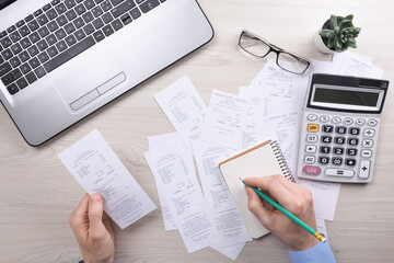 Fototapeta na wymiar Unrecognizable businessman using calculator on desk office and writing make note with calculate about cost at home office. finance accounting concept. tax , shopping, cost management