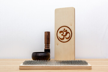 Still life on esoteric theme with sadhu desk, singing bowl and aromatic sticks. On bamboo table and white background.