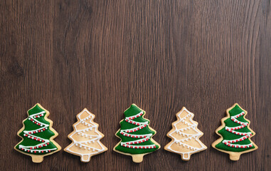 Top view of decorated Christmas tree cookie on wooden table background with copy space.