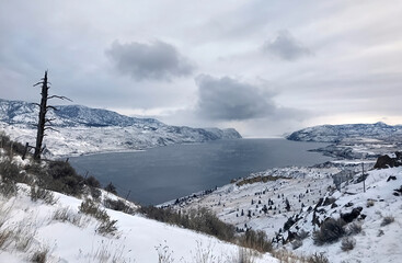 Frozen mountain Kamloops Lake in winter in cloudy weather. Winter mountain landscape. British Columbia, Canada. focus on the background