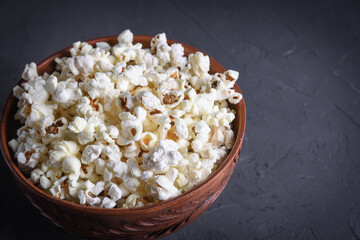 Salted popcorn in a bowl with 3D glasses on a table on a gray background. Top view