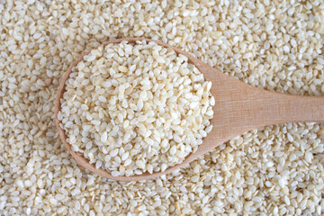 Sesame in a wooden spoon, top view.