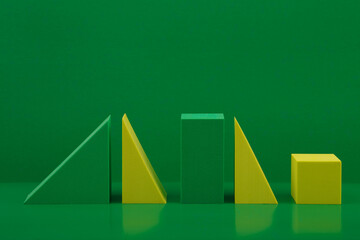 Duotone still life with yellow and green geometric figures on a green background with a space for...