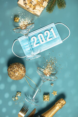 Two champagne glasses with splash of confetti, gifts and decorations over creative background