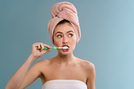 Nice beautiful girl brushing her teeth and looking aside