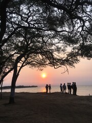 silhouette of family walking on the beach at sunset