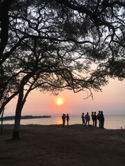 silhouette of family walking on the beach at sunset