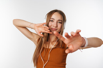 Happy beautiful woman dancing while listening music with headphones