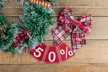 Big sales 50%, fifty percents with Christmas wreath on a old barn plank background, top view, copy space, flat layout. Christmas big sale.