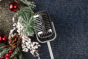 Retro microphone with Christmas decor on abstract background. Christmas music