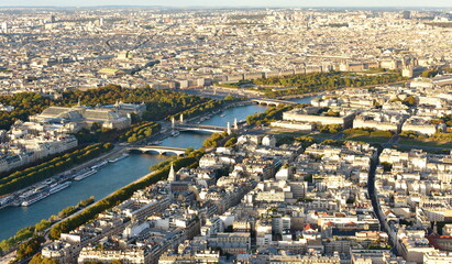 Parisian cityscape at sunset from Eiffel Tower. View of Seine River with Pont Alexandre III, Grand...