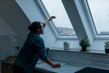 Man looking through the window how it rains