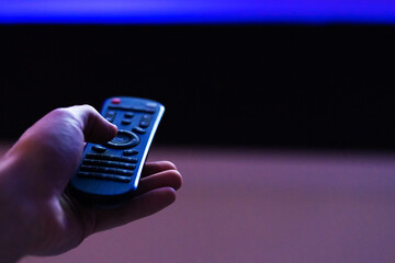 leisure at home. Watch TV. Remote control in hand close-up