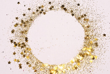 Round frame with gold glitter and glittering stars on light gray background.