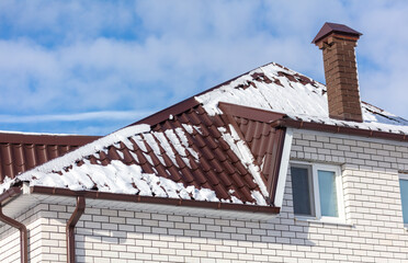 Snow on the roof of the house.