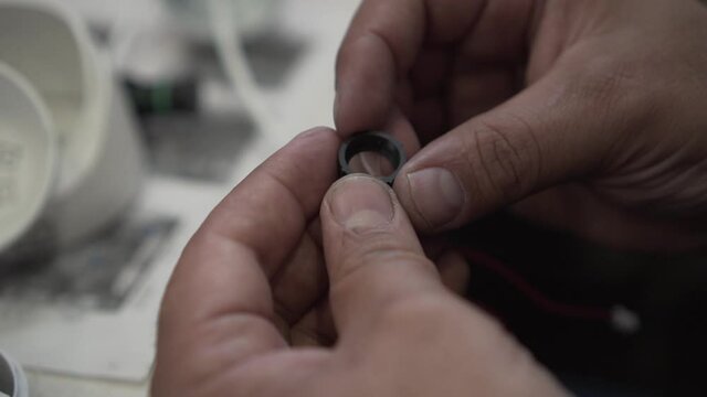 Male Hands are Holding a Plastic Ring in Their Hands, a Detail from the Device. Rubber Ring in Hand, Part of Plumbing, Plumbing system. Spins a Spare Part in his hand.